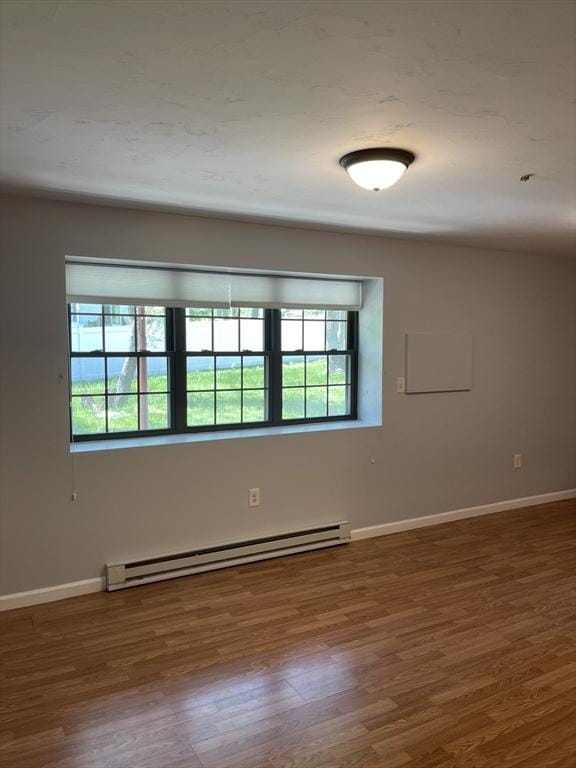 spare room featuring hardwood / wood-style flooring and a baseboard radiator