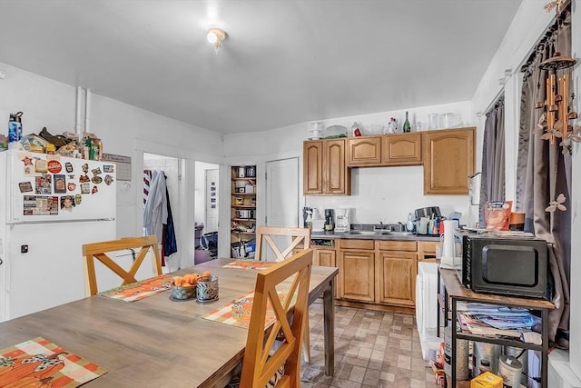 kitchen featuring white refrigerator and sink