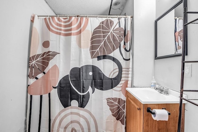 bathroom with vanity, a textured ceiling, and walk in shower