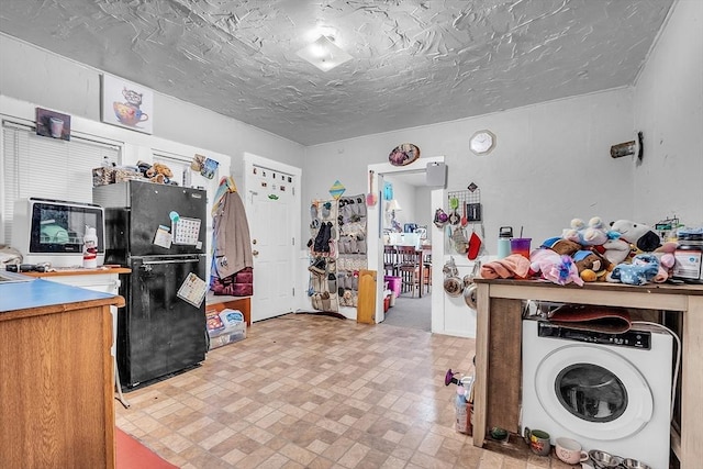 interior space with a textured ceiling and washer / clothes dryer