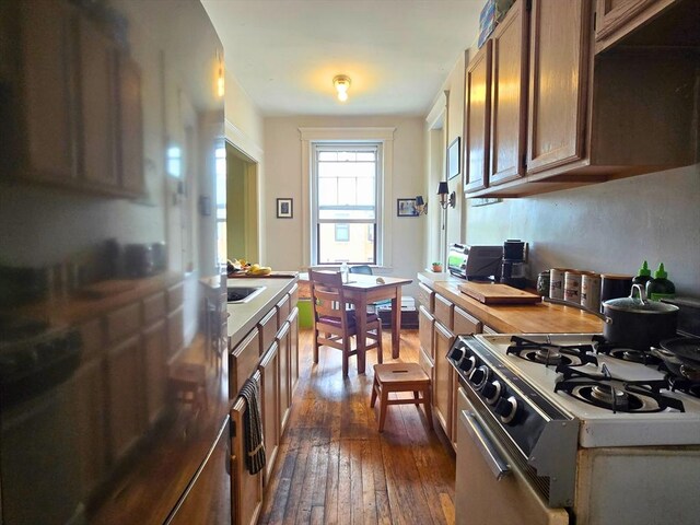 5 Crawford St Unit 9, Cambridge, MA 02139 - kitchen with freestanding refrigerator, gas range gas stove, dark wood-style flooring, and brown cabinets