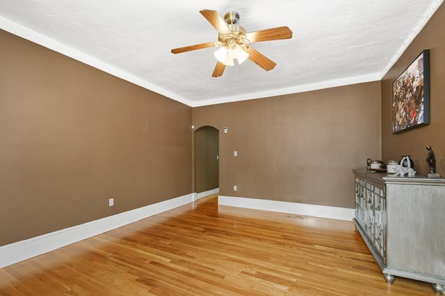 69 Greenwood St, Boston, MA 02122 - empty room with arched walkways, a ceiling fan, light wood-style flooring, and baseboards