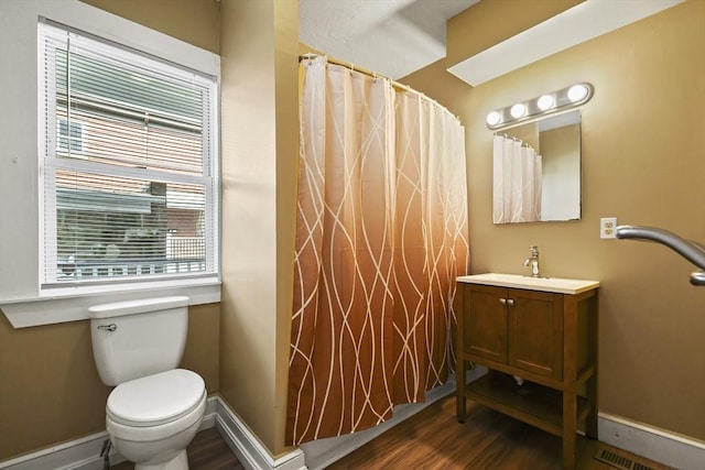 69 Greenwood St, Boston, MA 02122 - full bathroom with wood finished floors, vanity, toilet, and baseboards