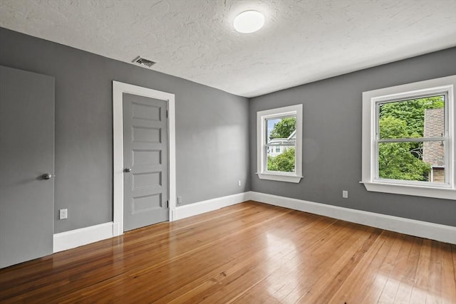69 Greenwood St, Boston, MA 02122 - empty room featuring baseboards, light wood finished floors, and a textured ceiling