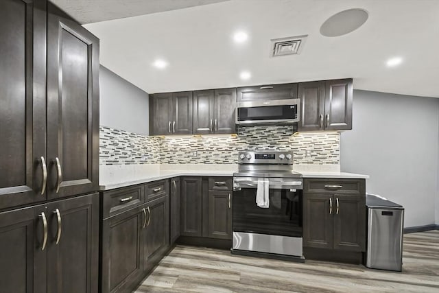 69 Greenwood St, Boston, MA 02122 - kitchen featuring appliances with stainless steel finishes, light countertops, light wood-type flooring, decorative backsplash, and recessed lighting