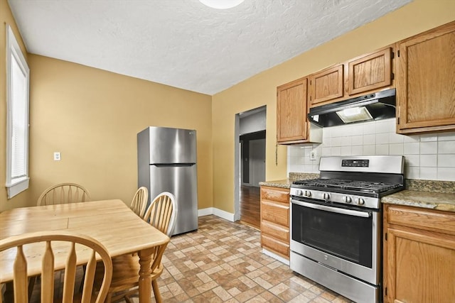 69 Greenwood St, Boston, MA 02122 - kitchen with appliances with stainless steel finishes, under cabinet range hood, backsplash, baseboards, and brick patterned floors