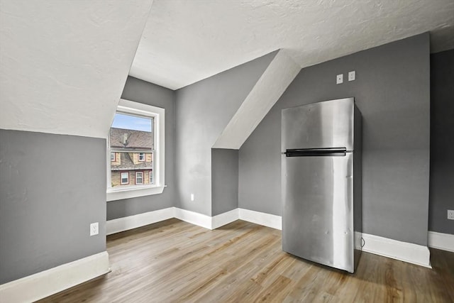 69 Greenwood St, Boston, MA 02122 - bonus room featuring baseboards, wood finished floors, vaulted ceiling, and a textured ceiling