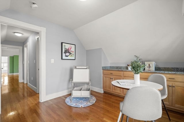 sitting room featuring light wood-style flooring, baseboards, and lofted ceiling