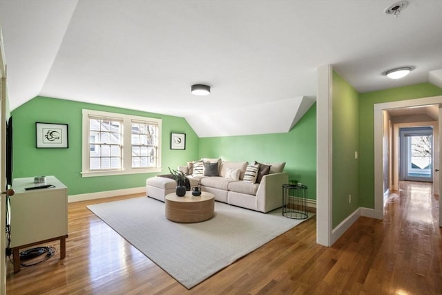 living room with baseboards, lofted ceiling, and wood finished floors