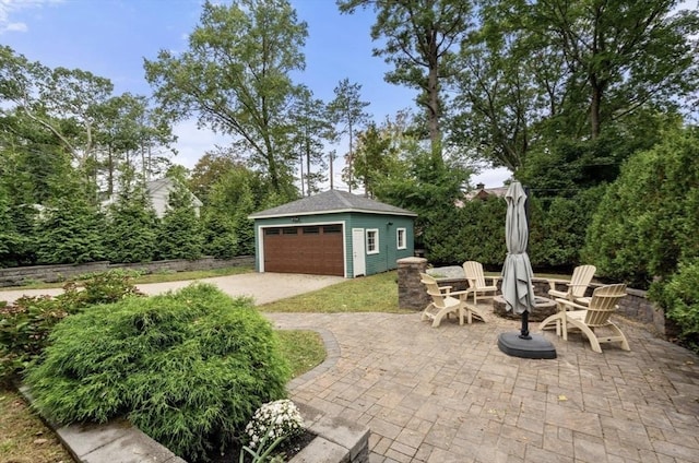 view of patio with an outbuilding and a garage