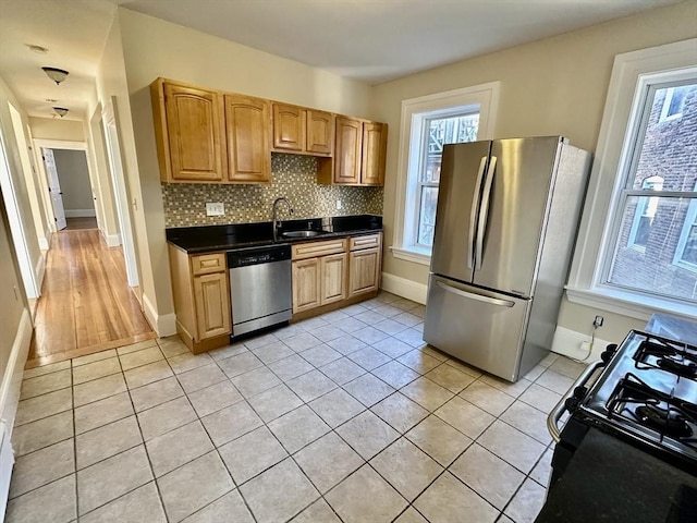 kitchen featuring light tile patterned floors, decorative backsplash, stainless steel appliances, and sink