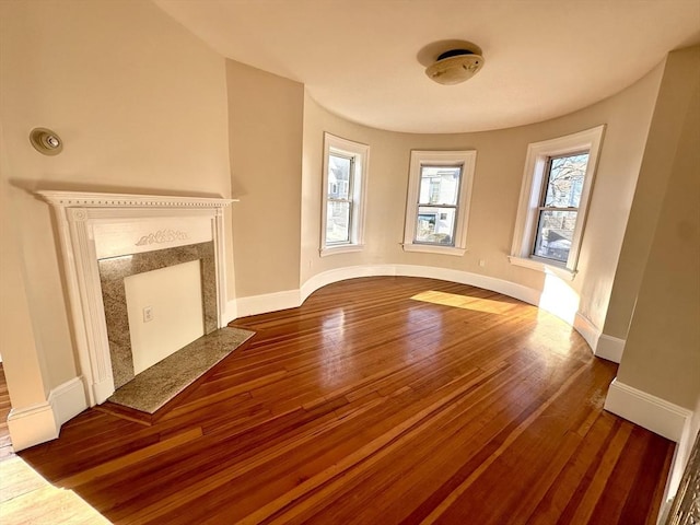 unfurnished living room with hardwood / wood-style flooring and a premium fireplace