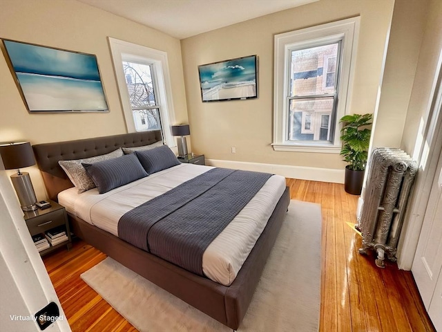 bedroom with hardwood / wood-style flooring and radiator heating unit