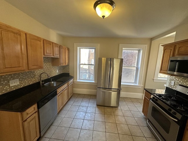 kitchen with stainless steel appliances, plenty of natural light, sink, and light tile patterned floors