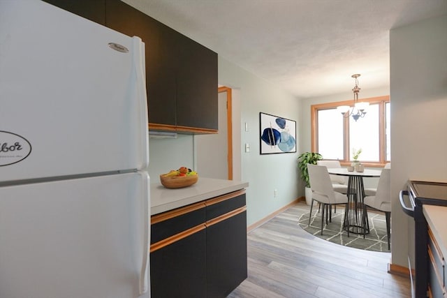 31 Blithewood Ave Unit 106, Worcester, MA 01604 - kitchen with freestanding refrigerator, light wood finished floors, electric range, a chandelier, and light countertops
