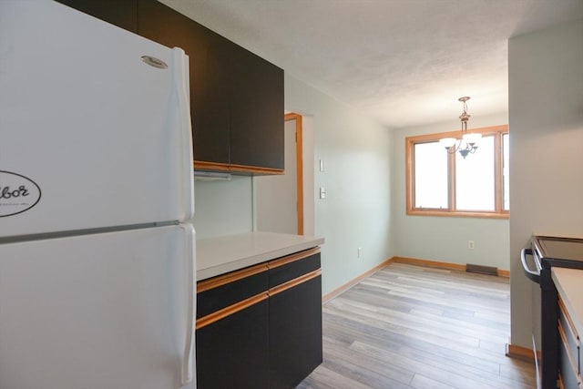 31 Blithewood Ave Unit 106, Worcester, MA 01604 - kitchen featuring freestanding refrigerator, light wood-style floors, stainless steel electric stove, light countertops, and a chandelier