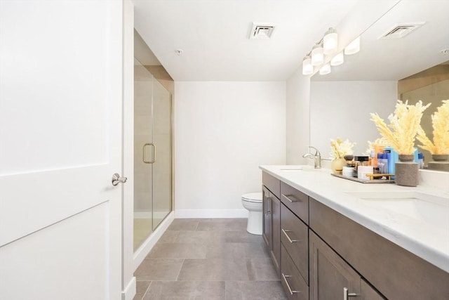 bathroom with vanity, a shower with door, and toilet