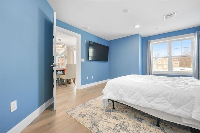 bedroom featuring a notable chandelier and light hardwood / wood-style floors