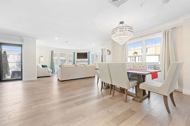 dining space featuring crown molding, a wealth of natural light, and light wood-type flooring