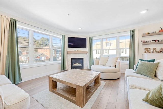 living room featuring light hardwood / wood-style flooring, crown molding, and a wealth of natural light