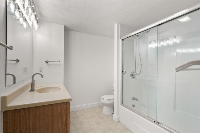 full bathroom with combined bath / shower with glass door, tile patterned flooring, vanity, toilet, and a textured ceiling