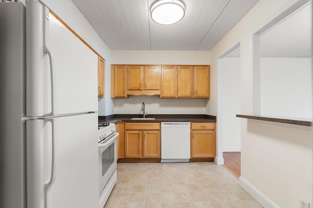 kitchen with sink, a textured ceiling, and white appliances