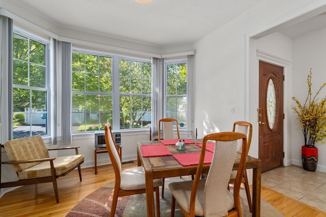 dining room with light wood-type flooring and a wealth of natural light