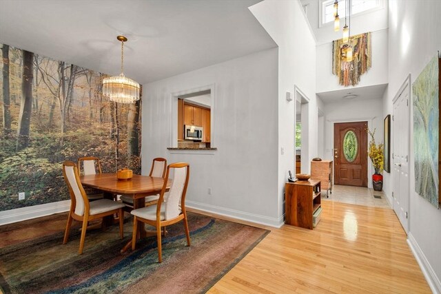 dining area with light wood-type flooring and a chandelier