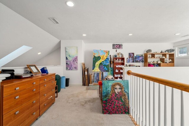 interior space featuring light colored carpet and lofted ceiling with skylight