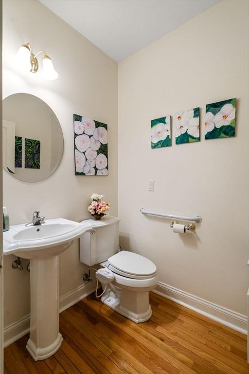 bathroom with toilet and hardwood / wood-style flooring