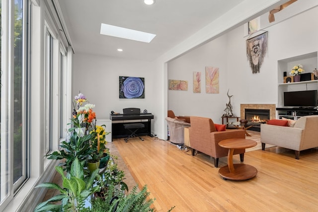 living room with a skylight and light hardwood / wood-style flooring