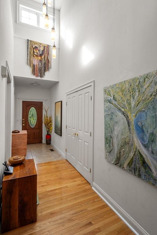 foyer entrance featuring a high ceiling and light hardwood / wood-style floors