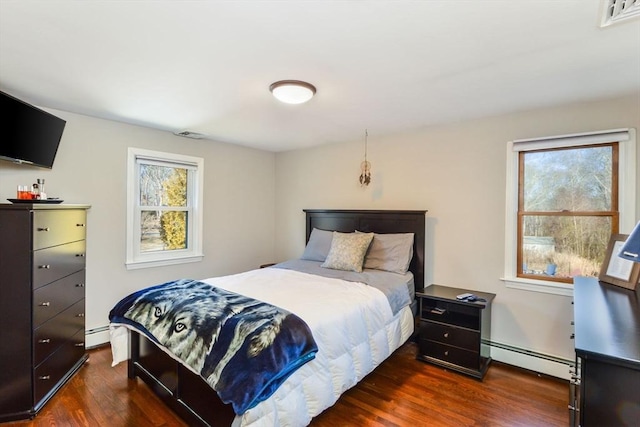 bedroom featuring a baseboard heating unit and dark hardwood / wood-style flooring