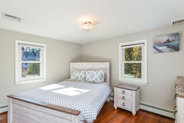 bedroom featuring a baseboard heating unit and dark hardwood / wood-style floors