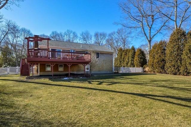 back of property featuring a wooden deck, a pergola, and a lawn