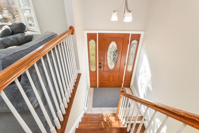 entryway featuring an inviting chandelier and a baseboard heating unit