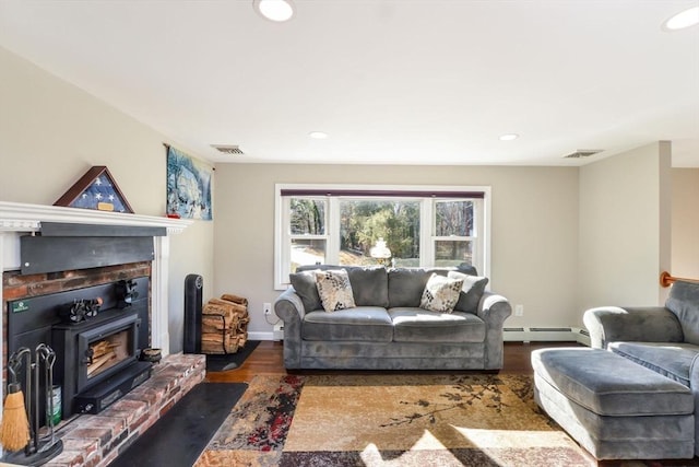 living room with a baseboard radiator, dark hardwood / wood-style floors, and a wood stove