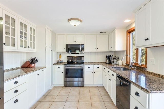 kitchen featuring dark stone countertops, sink, white cabinets, and appliances with stainless steel finishes