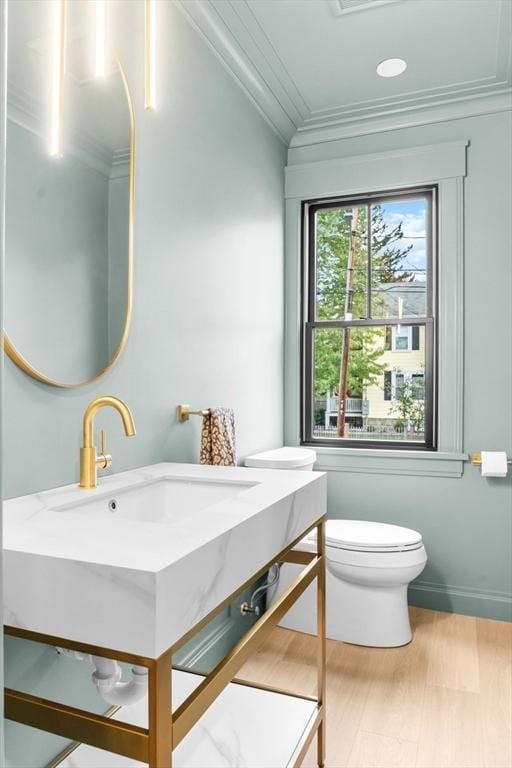 bathroom with ornamental molding, sink, hardwood / wood-style flooring, toilet, and lofted ceiling