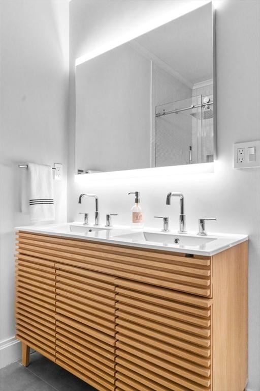 bathroom with tile patterned flooring, vanity, and a shower with shower door