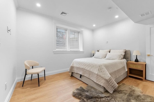 bedroom with light hardwood / wood-style floors and crown molding