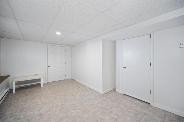 interior space featuring a drop ceiling and a baseboard radiator