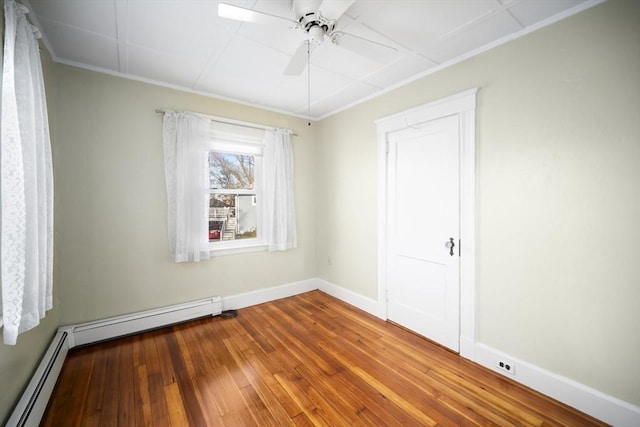 unfurnished room with baseboard heating, ceiling fan, crown molding, and wood-type flooring