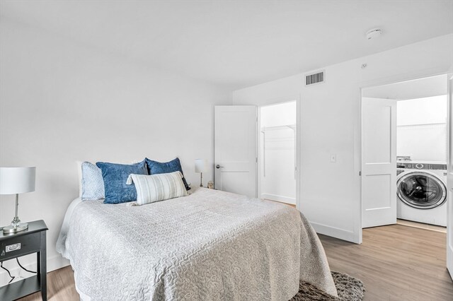 bedroom with hardwood / wood-style flooring and washer / dryer