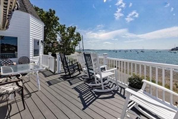 wooden terrace featuring a water view and outdoor dining area