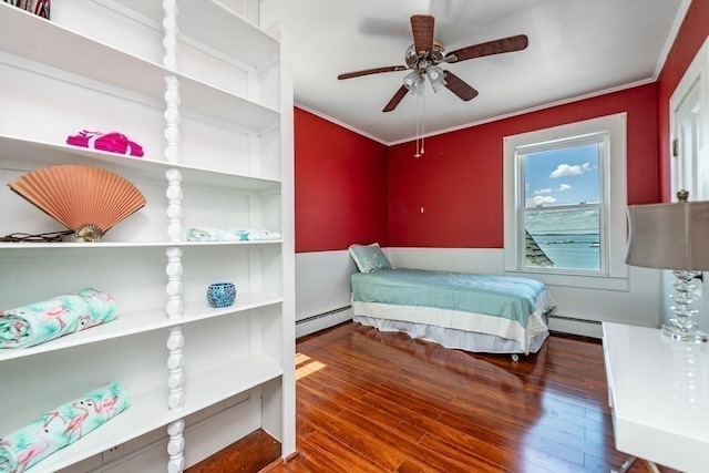 bedroom with baseboard heating, wood finished floors, a ceiling fan, and crown molding