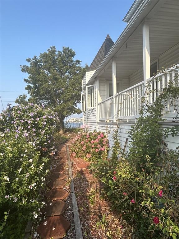 view of side of home with a balcony and a shingled roof