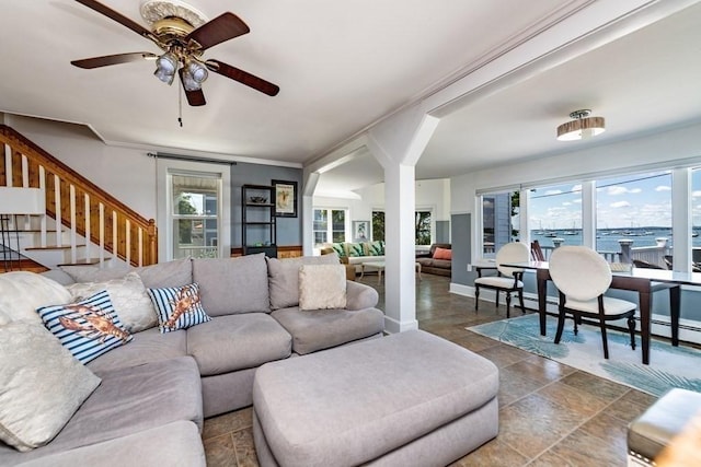 living room with a ceiling fan, arched walkways, stairway, crown molding, and baseboards