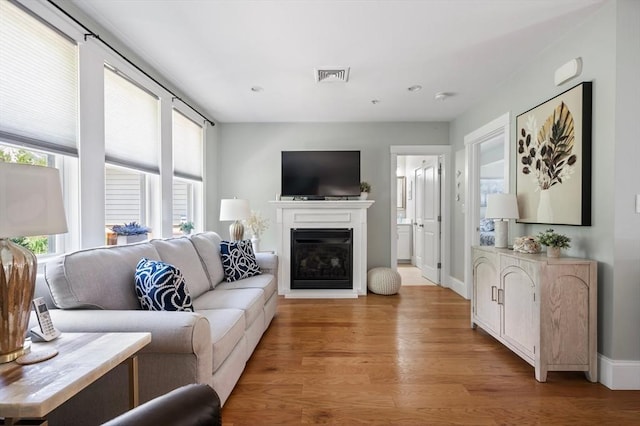 599 Washington St Unit 1, Pembroke, MA 02359 - living area with light wood-style flooring, a glass covered fireplace, and recessed lighting
