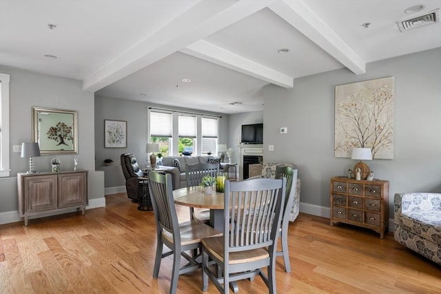 599 Washington St Unit 1, Pembroke, MA 02359 - dining area with beam ceiling, light wood-style flooring, and a fireplace